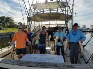 Group of anglers holding their catch on Pipe Dream Charters boat at the dock in Fernandina Beach, Florida