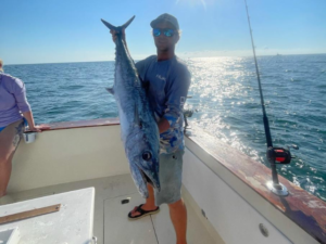 Angler holding a large King Mackerel caught on an offshore fishing charter near Amelia Island, Florida with Pipe Dream Charters.