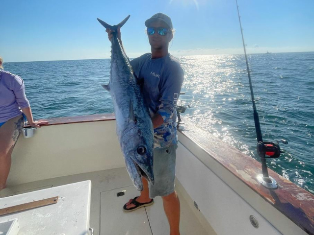 Angler holding a large King Mackerel caught on an offshore fishing charter near Amelia Island, Florida with Pipe Dream Charters.