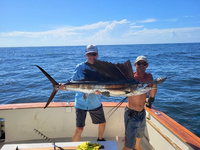 Two anglers on a fishing charter boat holding a large swordfish caught off the coast of Amelia Island, Florida.