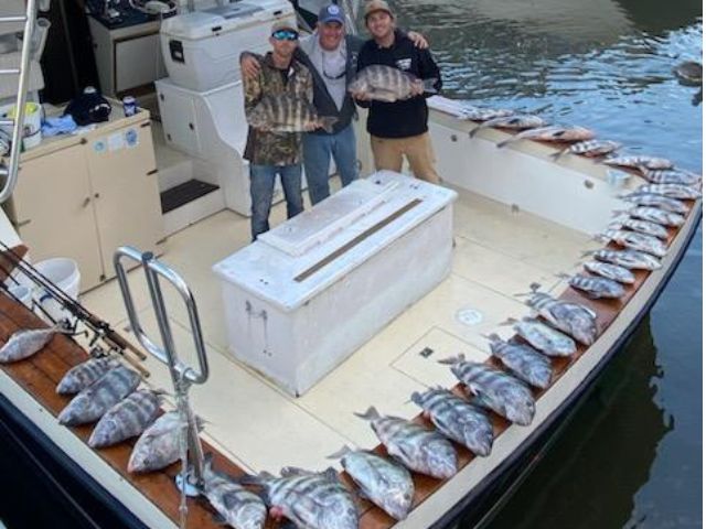 Anglers displaying their catch on the back of Pipe Dream Charters fishing boat