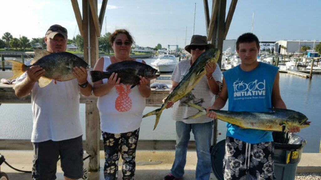 Anglers with a mahi-mahi and other fish on the deck of Pipe Dream III on the Gulf Stream off Amelia Island, Florida, a Pipe Dream Charters private deep sea fishing charter departing from Fernandina Harbor Marina