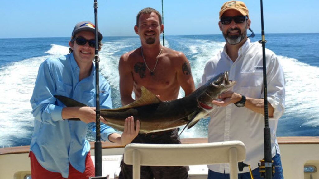 Anglers with a 30lb Cobia on the deck of Pipe Dream III at The Ledge off Amelia Island, Florida — a Pipe Dream Charters 8-hour private offshore fishing charter departing from Fernandina Harbor Marina